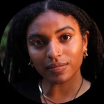 Black, queer femme Pronouns: they/she Long Black Dreadlocks Dark brown eyes Silver eyebrow piercing above right eye Gold studs on either nostril Gold septum ring