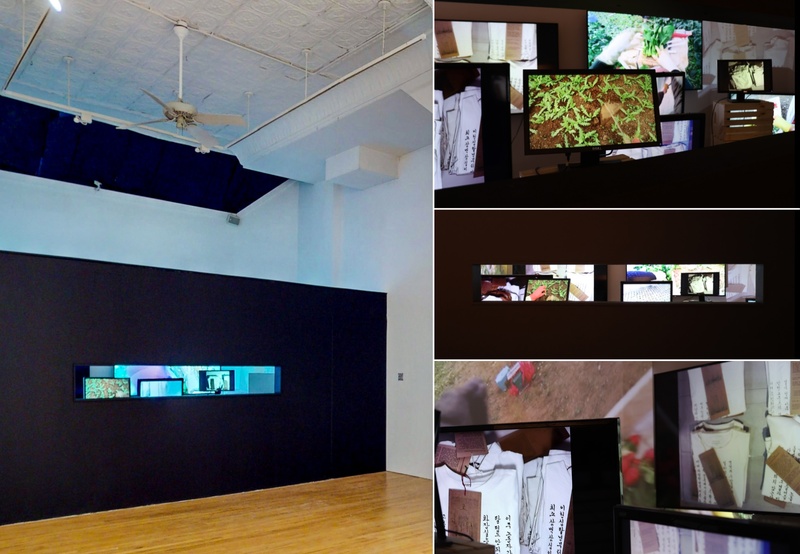  Multi-channel video installation viewed through narrow window on a black wall in a gallery space. 