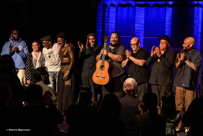  A large group clap together on stage after a performance. 