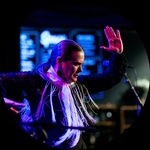 A white woman with grey/brown pulled back hair poses in the middle of dancing.