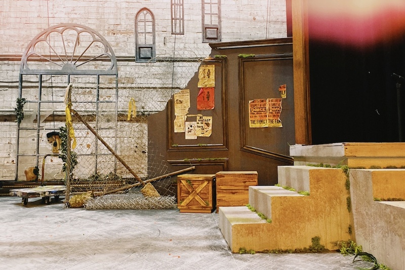  An image of an outdoor looking set with concrete stairs, chicken wire and other props. 