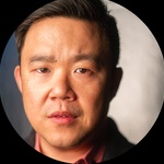 A headshot of a Filipino-Chinese cis male with short dark hair and olive skin.