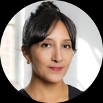 A headshot of a Latinx woman with long dark hair tied in a bun.