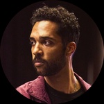 Light-skinned Black person, short black curly hair, brown eyes