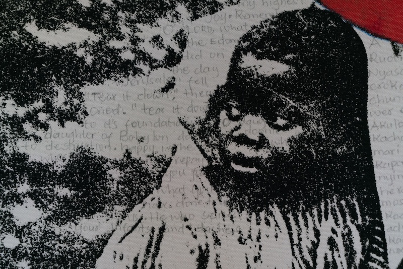  A close up on a print of a Black child printed in black and white. In pencil there is faint writing on the print. 
